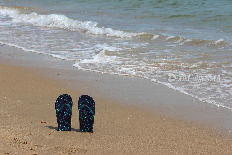 人字拖/丁字裤站在沙滩上，沙滩凉鞋